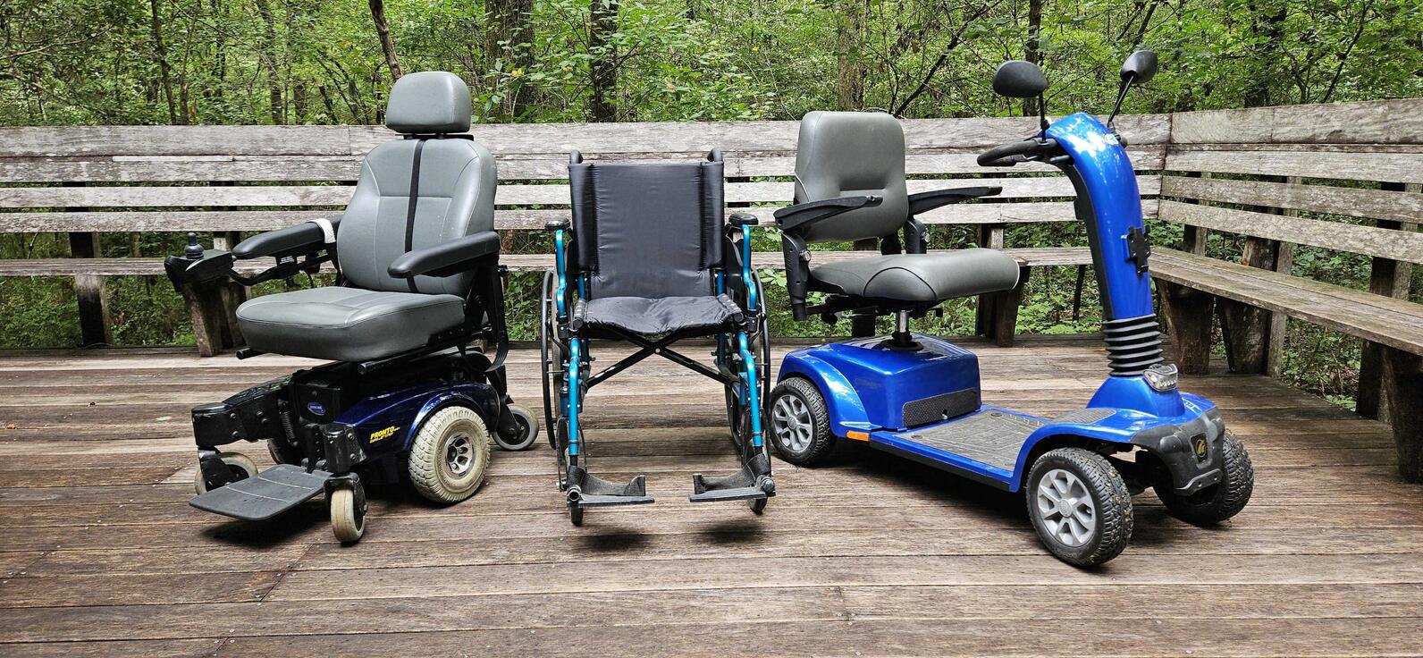 From left to right, an electronic wheelchair, a push (analog?) wheelchair, and an electric scooter. All three are available to borrow for the boardwalk at no cost.